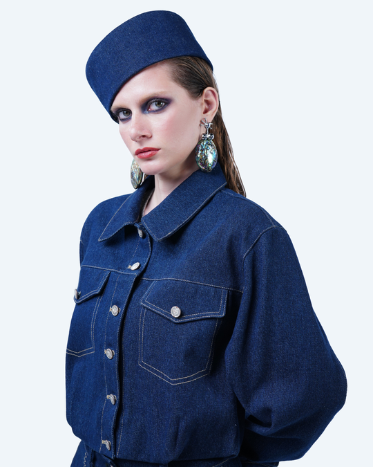 Model wearing Hüna Denim Jacket – cropped structured denim jacket with front flap pockets and contrast topstitching from the Volume Noir Collection.