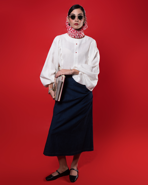 Hüna Nina Blouse styled with denim skirt — sculptural puff sleeve blouse with contrast red buttons, limited edition piece