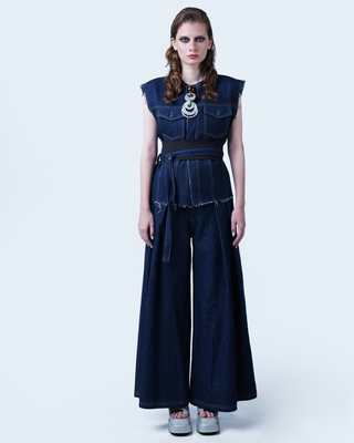 Model wearing Hüna Denim Vest – structured sleeveless silhouette with raw-edge hem and contrast topstitching from the Volume Noir Collection.
